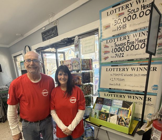 David and Donna Travers with the many signs posted after customers bought winning lottery tickets at Travers Food Market, including a million dollar lottery winner. (PEG DEGRASSA - DAILY TIMES)