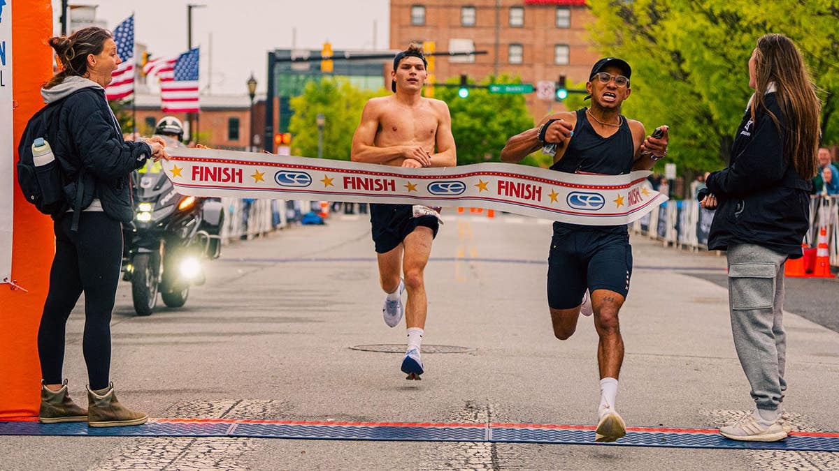 Marathon runner crosses the line in front of his opponent