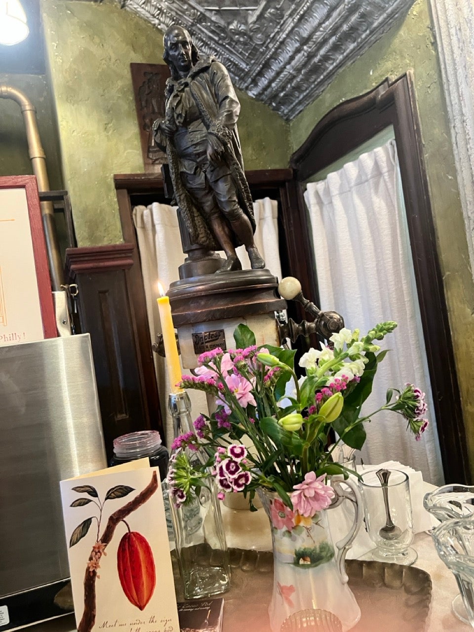 A statue above a floral arrangement in the center of a table at the Cacoa Pod event space in Old City Philadelphia.