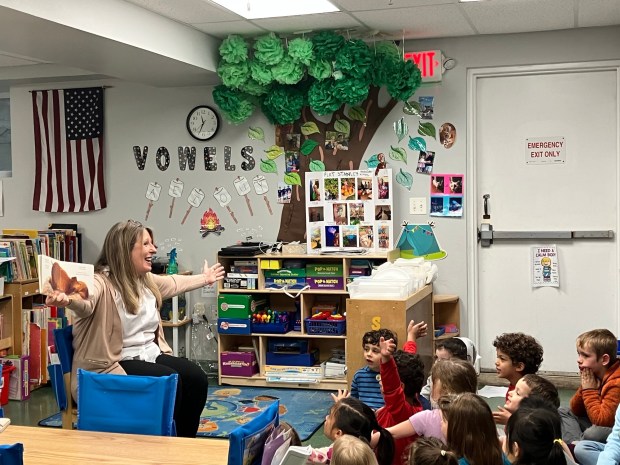SJU President Dr. Cheryl McConnell's outstretched arms illustrate her story time selection "I LOVE YOU THIS MUCH" during her visit to The Children's School. (Photo submitted by Mary Brown)