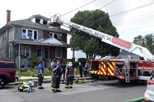 Reading firefighters put out hot spots after a two-alarm blaze tore through a home at North Carroll Street and Gregg Avenue in Reading's 18th Ward on Friday morning. (BILL UHRICH/READING EAGLE)