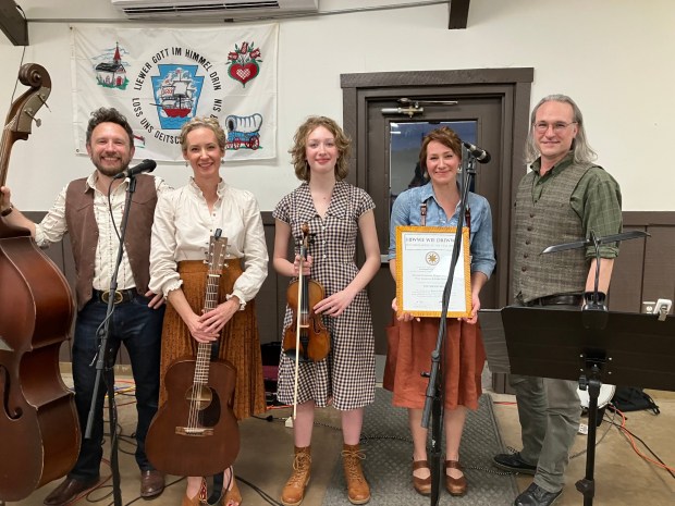 The Shooflies PA German family band received the Hiwwe wie Driwwe, Here like There, certificate from PA German Cultural Heritage Center director Patrick Donmoyer, far right. The Shooflies were the performing artists for 2025 which commemorated their Palatinate Tour featuring five concerts in the Pfalz region of Germany. (Photo courtesy of Mary Laub)