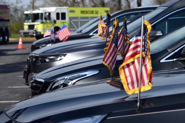 Funeral vehicles are parked outside Fleetwood High School prior to the viewing Friday, April 10, 2026, Members of area fire companies wait outside Fleetwood High School prior to the viewing Friday, April 10, 2026, for Walnuttown Fire Chief Jeffory L. Buck and Assistant Chief Robert R. Shick Jr. (BILL UHRICH/READING EAGLE)