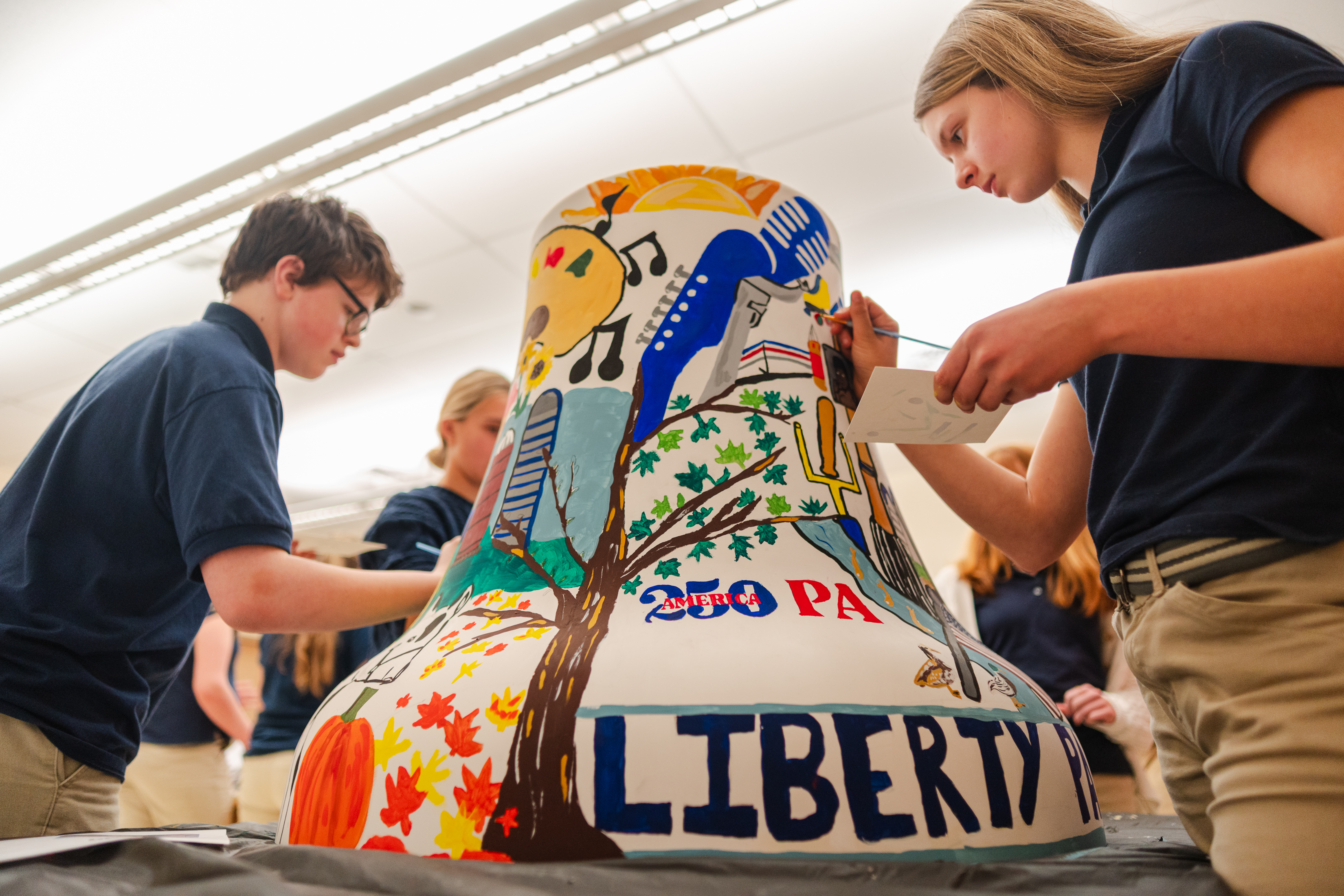 Owen Hartzell, left, and Addie Faust, right, paint Schuylkill County’s...