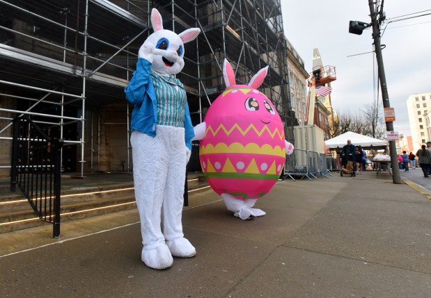 The Easter bunny and an Easter egg wave to vehicles during the Family to Family Easter Giveaway on N. Washington Ave. in Scranton Wednesday, April 1, 2026. (SEAN MCKEAG / STAFF PHOTOGRAPHER)