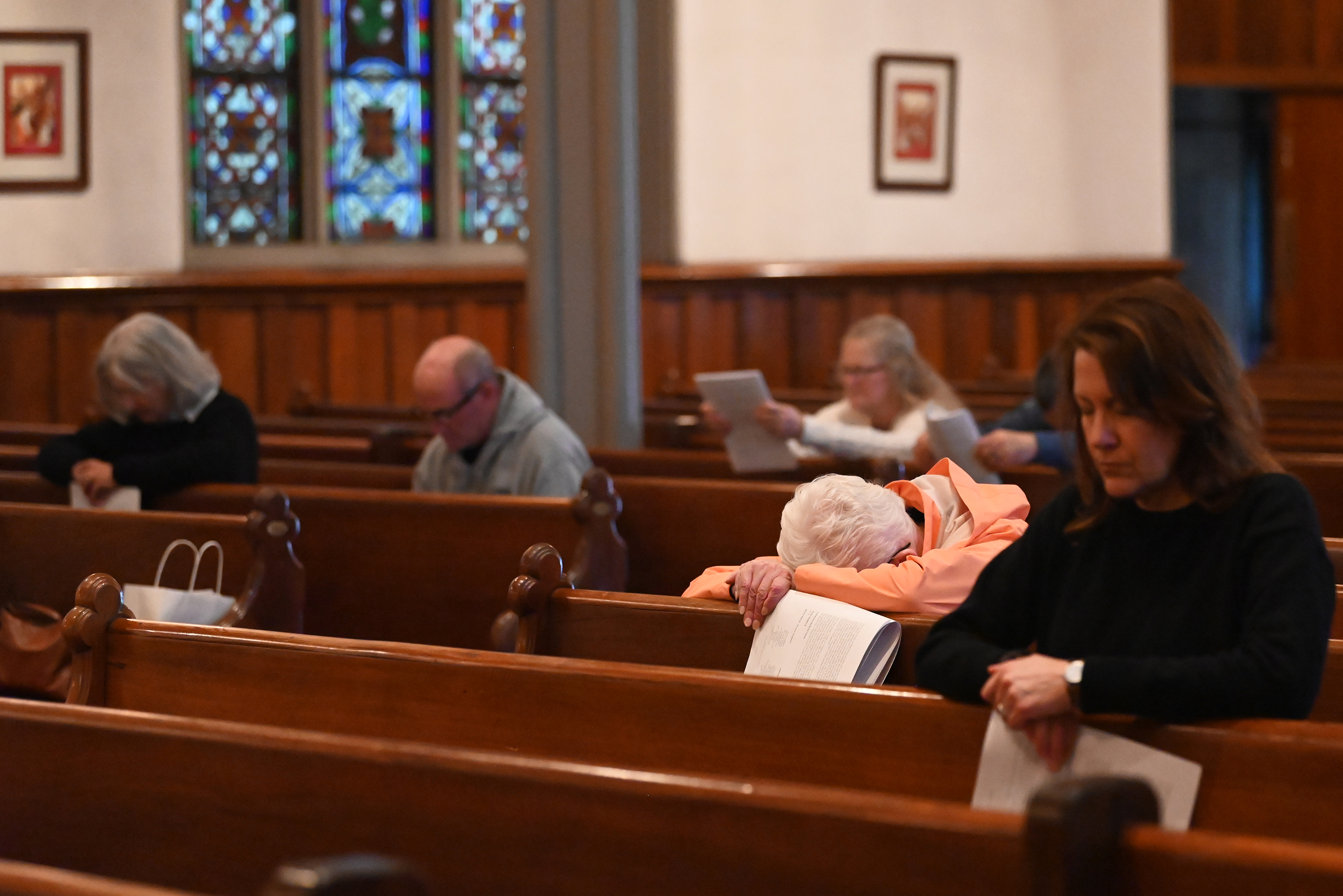 Worshipers bow their heads in a moment of silence during...