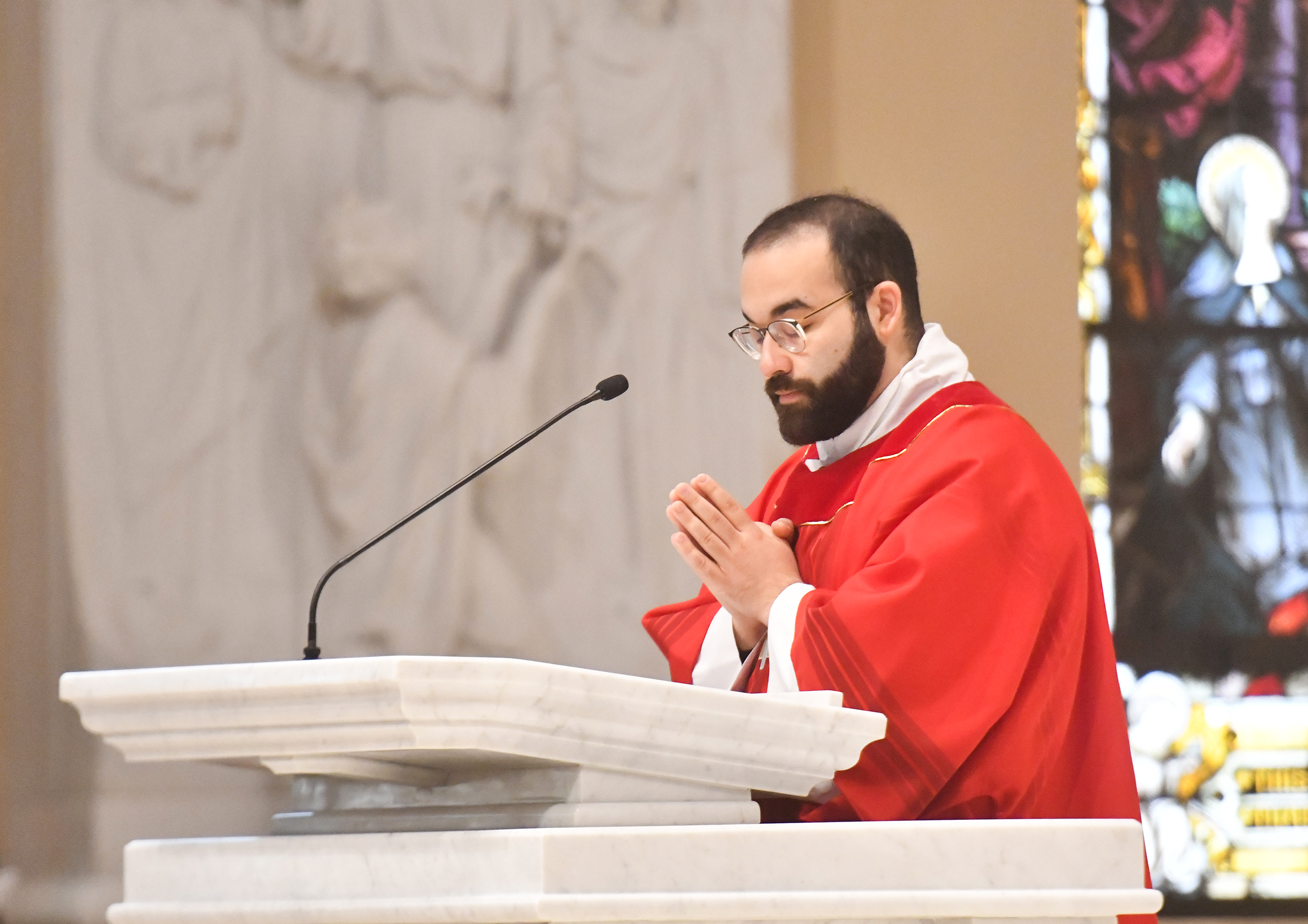 Deacon Jan Carlo Perez recites Scripture during the Commemoration of...