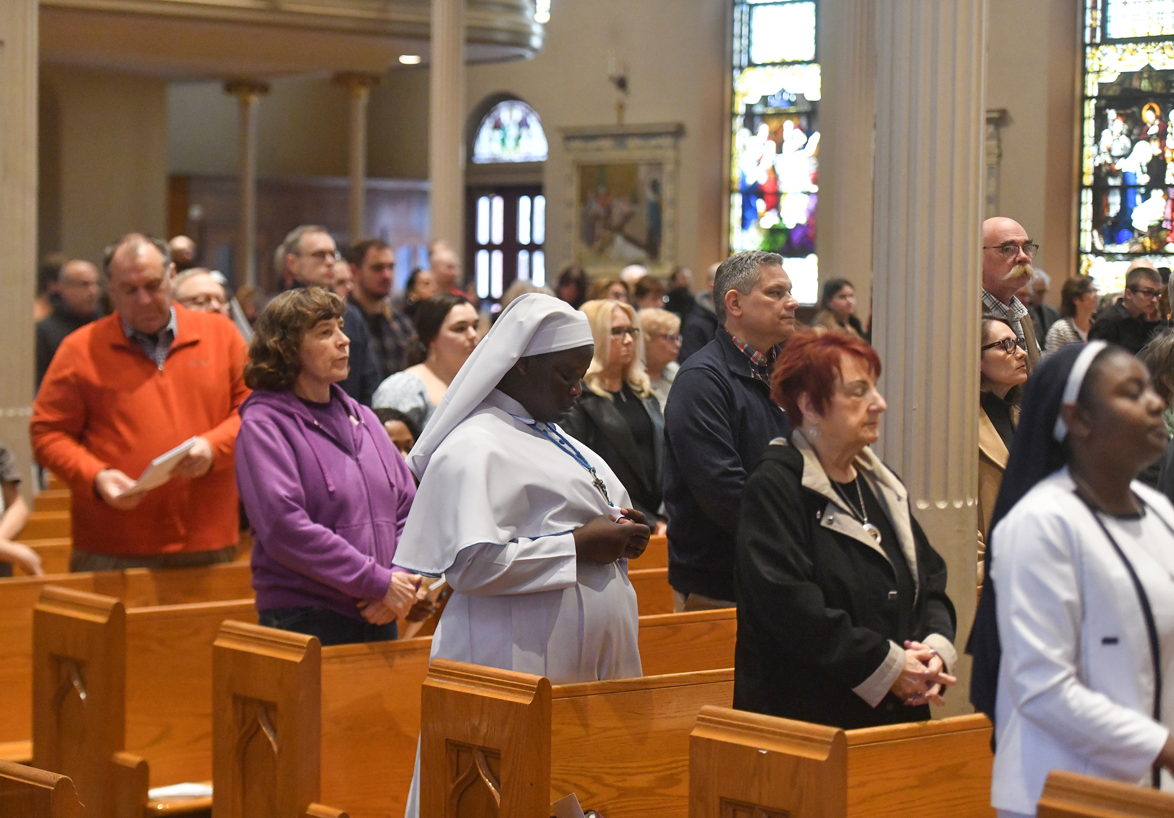 People attend the Good Friday Liturgy at St. Peter’s Cathedral...
