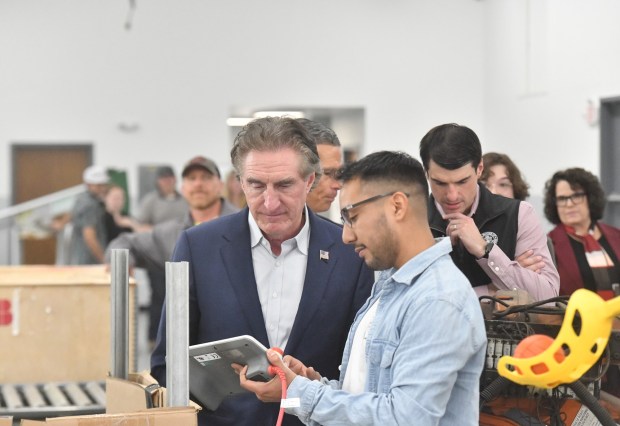 U.S. Secretary of the Interior Doug Burgum talks with Karim Vasquero, student with Lackwanna College's Robotics and Automation program, in the ABB Robotics training facility in Scranton.