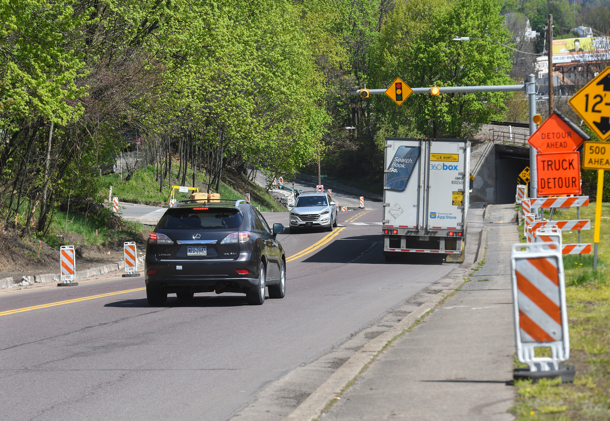 Vehicles travel on North Main Avenue past construction work in...