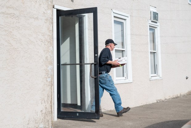 A customers exits Ghigiarelli's with pizza in Old Forge on Friday, April 03, 2026. (REBECCA PARTICKA/STAFF PHOTOGRAPHER)