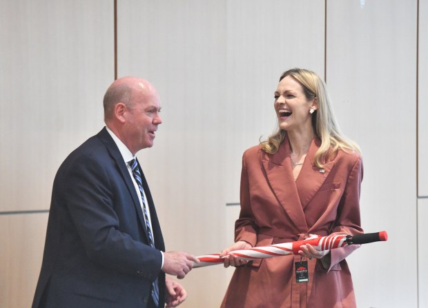 Bob Durkin, president and CEO of the Greater Scranton Chamber of Commerce, gifts Scranton Mayor Paige Gebhardt Cognetti an umbrella before the State of the City Address held in the Kane Forum at University of Scranton's Leahy Hall in Scranton Wednesday, April 22, 2026. (SEAN MCKEAG / STAFF PHOTOGRAPHER)