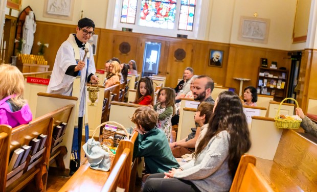 Rev. Giuseppe Esposito sprinkles holy water on prepared Easter baskets Saturday, April 4, 2026, during a blessing of the food baskets on Holy Saturday at St. Anne Catholic Church in Bethlehem. (April Gamiz/The Morning Call)