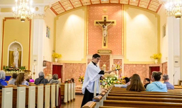Rev. Giuseppe Esposito sprinkles holy water on prepared Easter baskets Saturday, April 4, 2026, during a blessing of the food baskets on Holy Saturday at St. Anne Catholic Church in Bethlehem. (April Gamiz/The Morning Call)