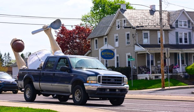 The top half of Giant Chip arrives in the back of a pick-up truck Thursday, April 16, 2026, at Inside Scoop in Coopersburg. The popular, 25-foot-high statue was toppled by high winds in February. Roadside artist Mark Cline, who built the statue, was on site Thursday to repair it. (Monica Cabrera / The Morning Call)