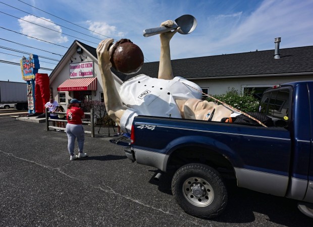 The top half of Giant Chip arrives in the back of a pick-up truck Thursday, April 16, 2026, at Inside Scoop in Coopersburg. The popular, 25-foot-high statue was toppled by high winds in February. Roadside artist Mark Cline, who built the statue, was on site Thursday to repair it. (Monica Cabrera / The Morning Call)