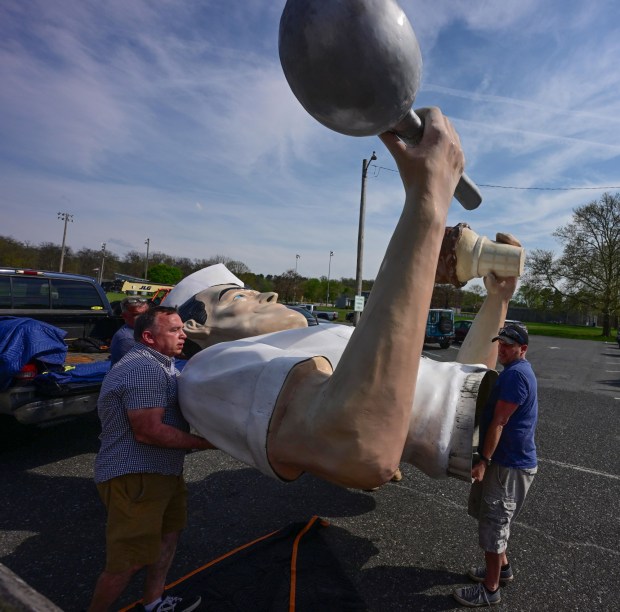 The top half of Giant Chip arrives in the back of a pick-up truck Thursday, April 16, 2026, at Inside Scoop in Coopersburg. The popular, 25-foot-high statue was toppled by high winds in February. Roadside artist Mark Cline, who built the statue, was on site Thursday to repair it. (Monica Cabrera / The Morning Call)