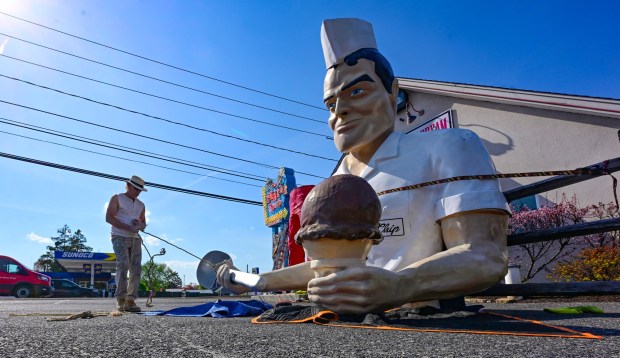 Roadside artist Mark Cline prepares the top half of the Giant Chip statue Thursday, April 16, 2026, at Inside Scoop in Coopersburg. The popular, 25-foot-high statue was toppled by high winds in February. Cline, who built the statue, was on site Thursday to repair it. (Monica Cabrera / The Morning Call)