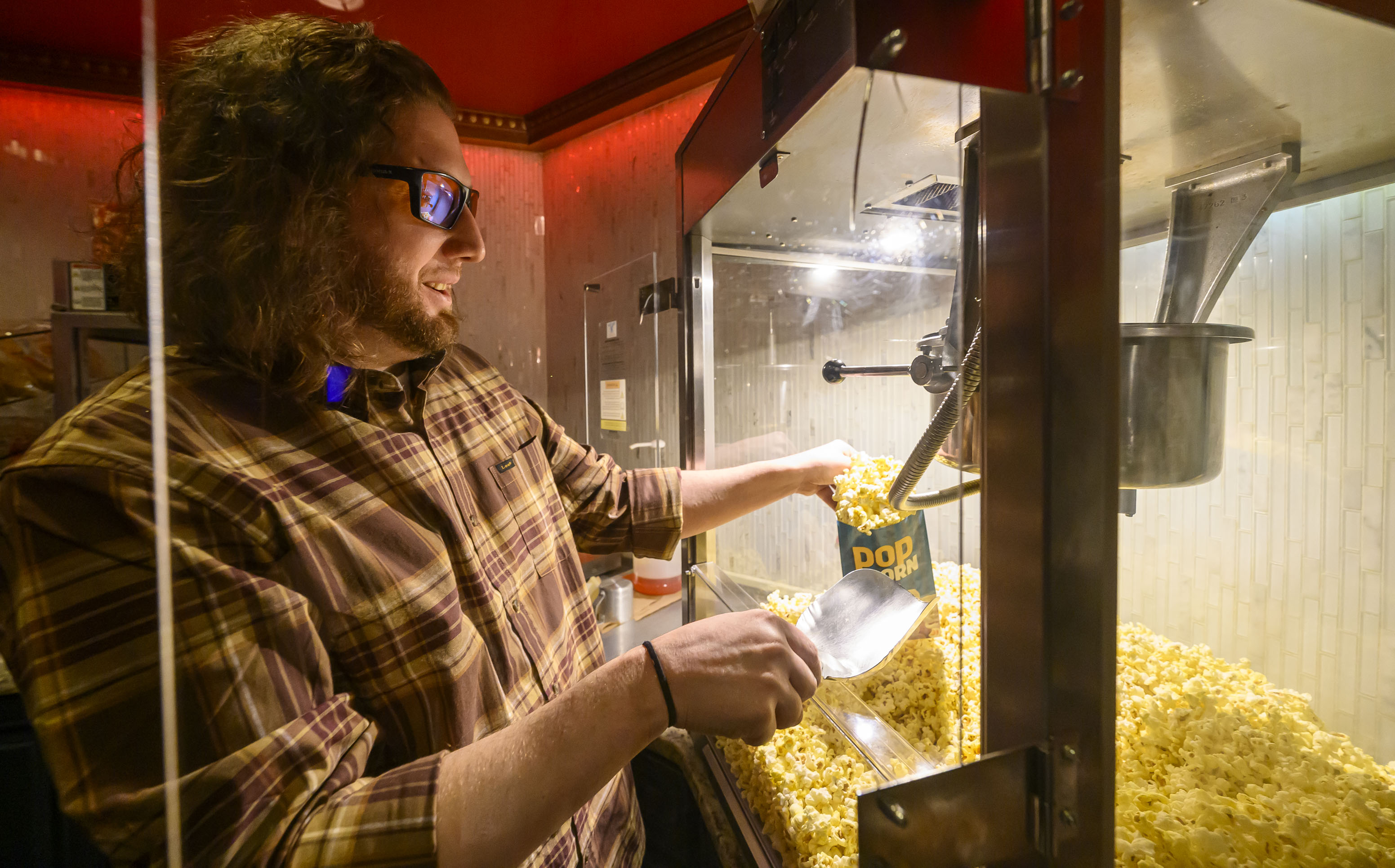 Emmaus Theatre co-owner Robert Audibert fills popcorn bags Wednesday, April...