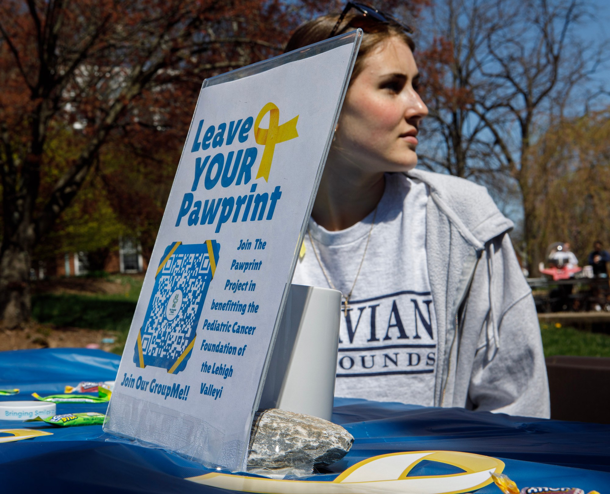 Liz Lepley, a Moravian University freshman from Bayville, New Jersey, works the Pawprint table during Pawapalooza on Saturday, April 11, 2026, at Moravian University's Priscilla Payne Hurd Academic Complex in Bethlehem. The event supports the Pawprint Project, a student-led organization raising money for the Pediatric Cancer Foundation of the Lehigh Valley. It features live music, games and other activities.(Jane Therese/Special to The Morning Call)