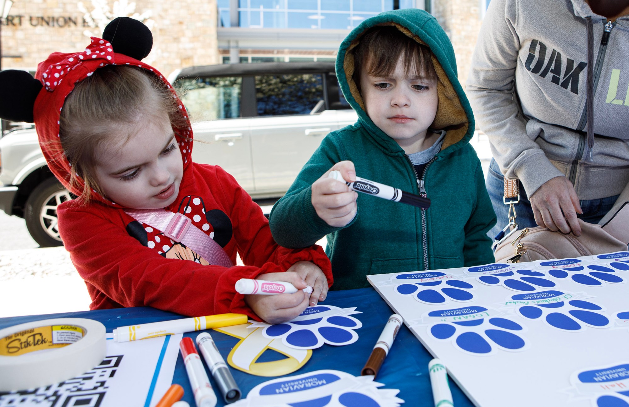 Ryleigh Smith, 5, and her brother Ryder, 6, from Bethlehem write their names on a paw print during Pawapalooza on Saturday, April 11, 2026, at Moravian University's Priscilla Payne Hurd Academic Complex in Bethlehem. The event supports the Pawprint Project, a student-led organization raising money for the Pediatric Cancer Foundation of the Lehigh Valley. It features live music, games and other activities.(Jane Therese/Special to The Morning Call)