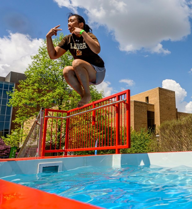 Lehigh University student Keshia Vitalicio jumps into cold water Friday, April 17, 2026, during Special Olympics Pennsylvania's Mobile Polar Plunge at Lehigh University in Bethlehem. More than 100 Lehigh students and staff jumped into the water to raise money and awareness for athletes with intellectual and developmental disabilities. (April Gamiz/The Morning Call)