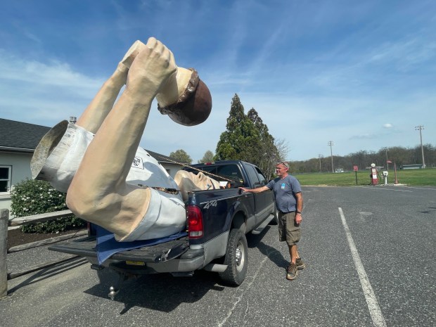 The top half of Giant Chip arrives in the back of a pick-up truck Thursday, April 16, 2026, at Inside Scoop in Coopersburg. The popular, 25-foot-high statue was toppled by high winds in February. Roadside artist Mark Cline, who built the statue, was on site Thursday to repair it. (Monica Cabrera / The Morning Call)