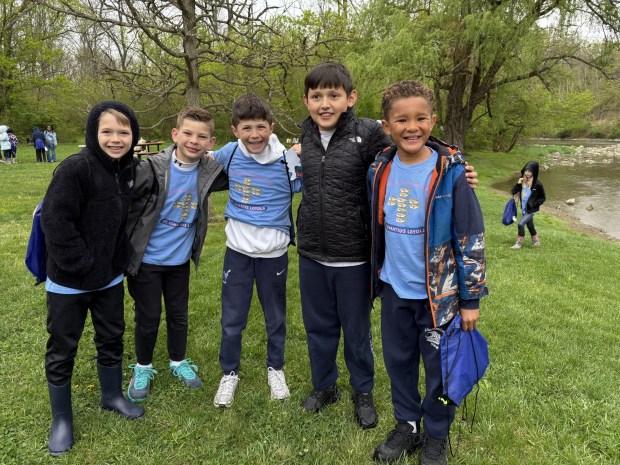Jacob Rebilos, left, joins classmates Adam Kreitz, Christian Tiedeken and Valentino Flores, third-graders at St. Ignatius Loyola Regional School, as they arrive at Blue Marsh Lake for a field trip to release more than 120 trout fingerlings raised from eggs in an aquarium at their Spring Township school. (STEVEN HENSHAW - READING EAGLE)