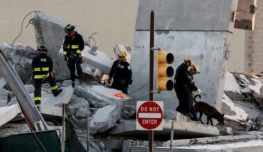 Firefighters and Pennsylvania Urban Search and Rescue look through the site of the partial parking garage collapse in Grays Ferry on Sunday, April 12, 2026 in Philadelphia.