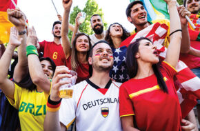 Soccer fans drinking and cheering at game