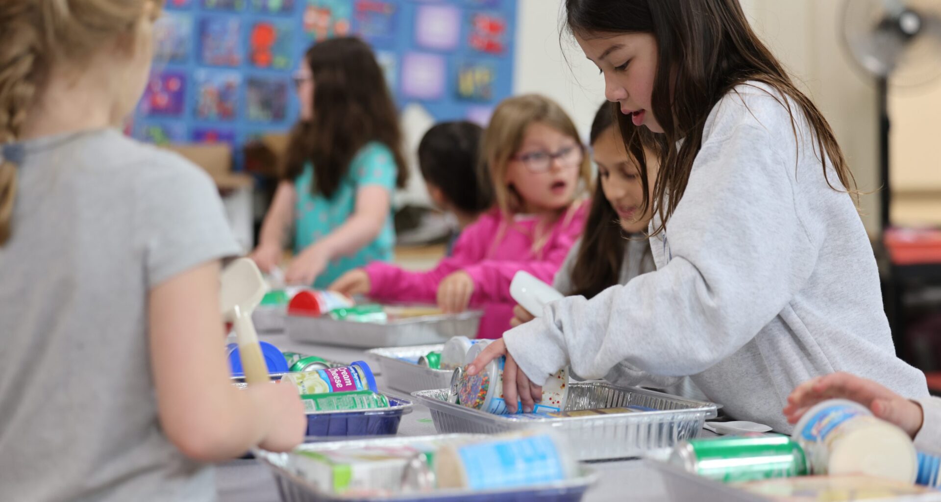 students put cake and frosting inside box