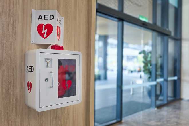 AED or Automated External Defibrillator installed on wall in hotel lobby as first aid in heart attack situation. AED or Automated External Defibrillator installed on wall in hotel lobby as first aid in heart attack emergency situation.