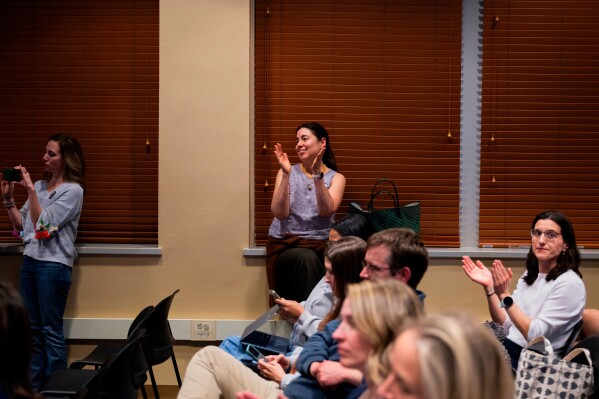 Attendees clap during a school board meeting at the Lower Merion School District Administration Building on Monday, May 11, 2026, in Ardmore, Pa. (AP Photo/Joe Lamberti)