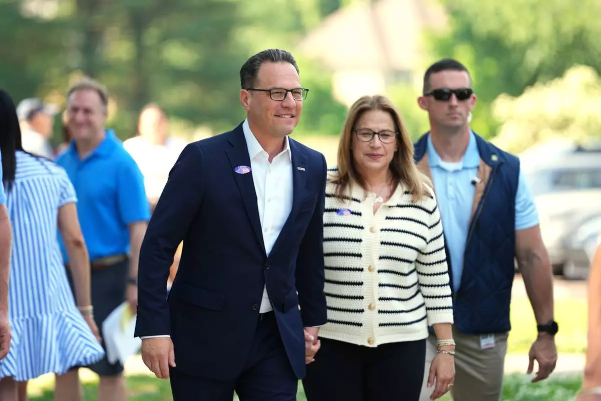 Pennsylvania Gov. Josh Shapiro, accompanied by his wife Lori Shapiro, walks from his polling place in Rydal, Pa., Tuesday, May 19, 2026. (AP Photo/Matt Rourke)