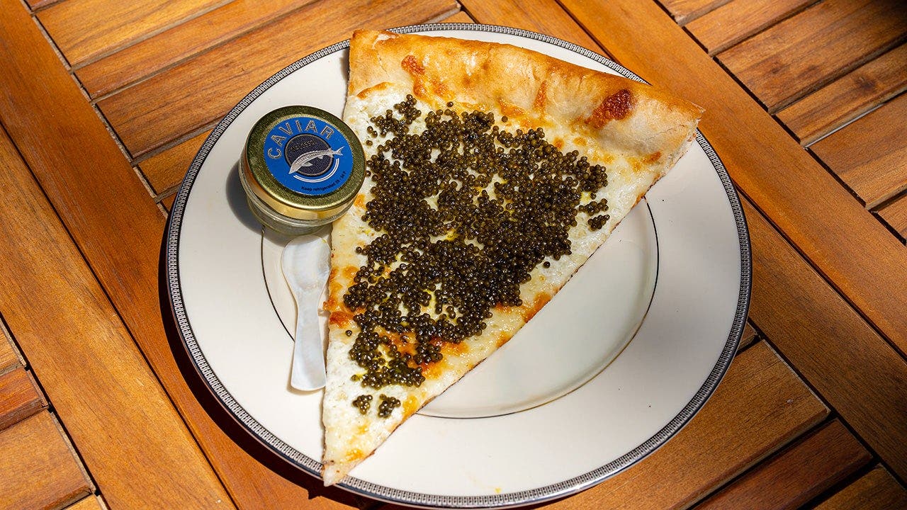 A $55 caviar pizza slice is served on a gold plate at a Philadelphia pizza shop