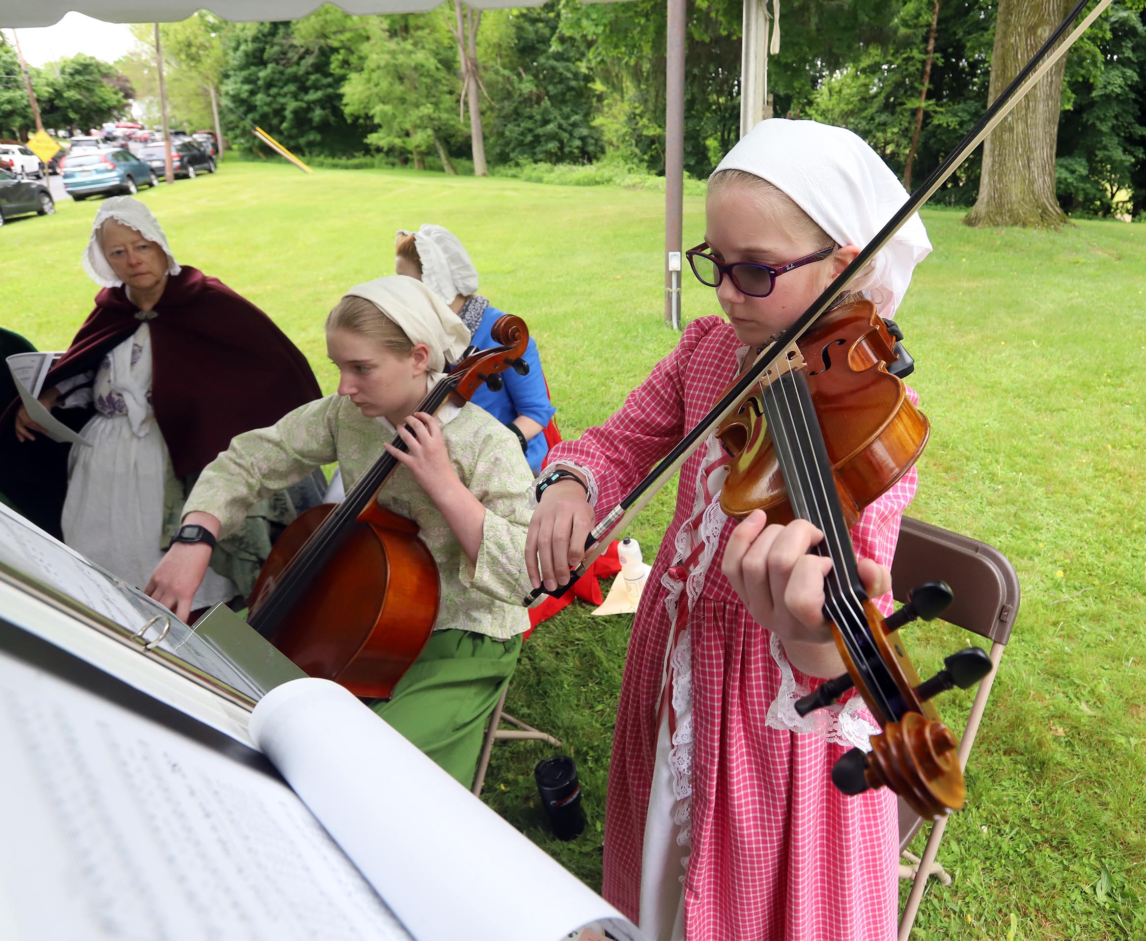 Renactors Julie and Makayla Shaver play period music during a...