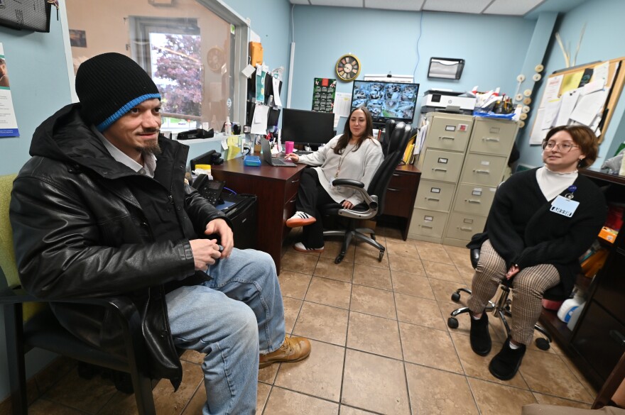 Anthony Weekes speaks with Wright Center employees Ivy Nataloni and Neena Beggin. He received health care from The Wright Center's mobile street medicine clinic.