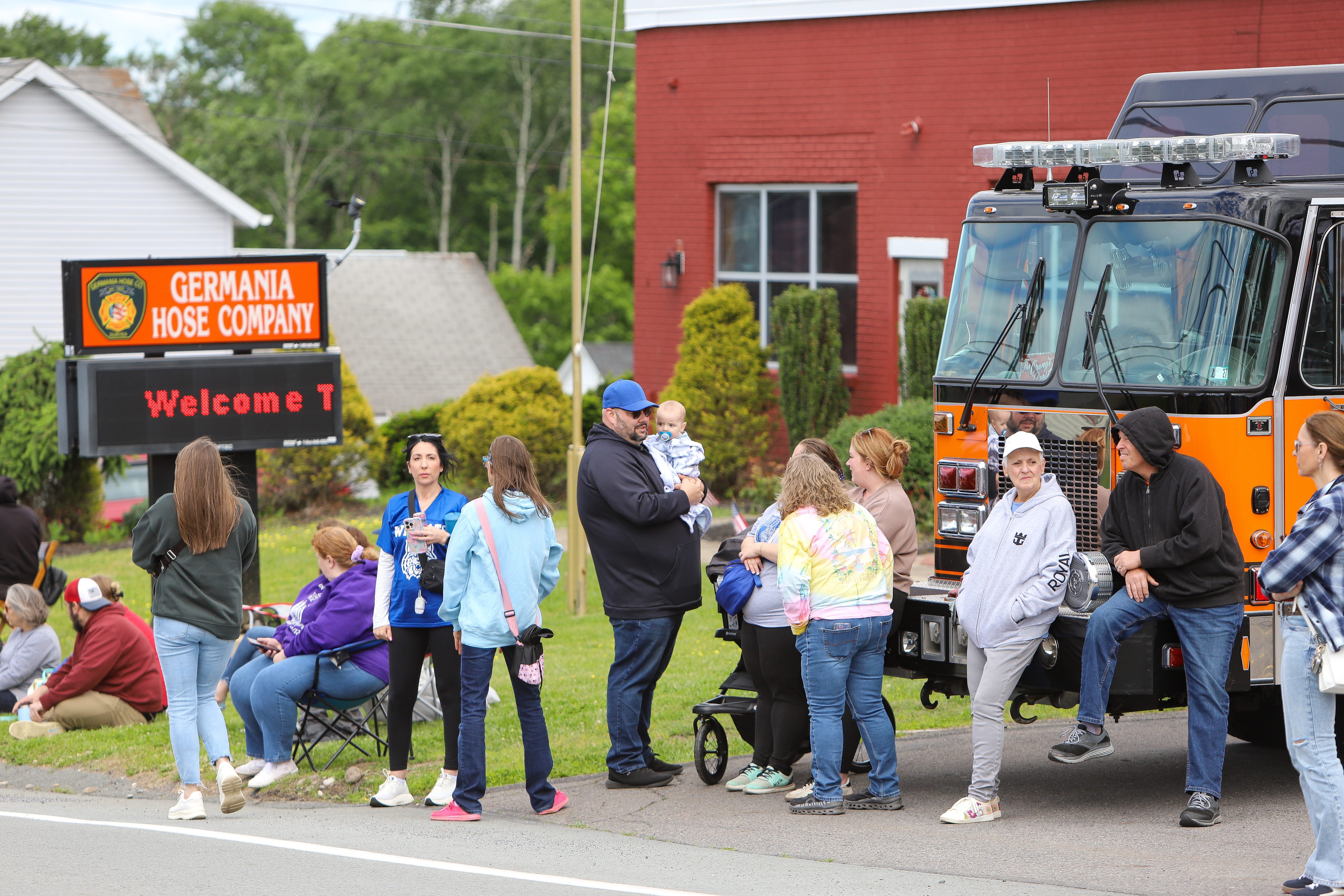People watch the passing trucks during the Duryea Borough 125th...