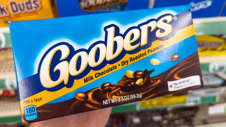 A person holding a box of Goobers