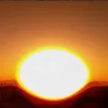 An enlarged sun over the horizon