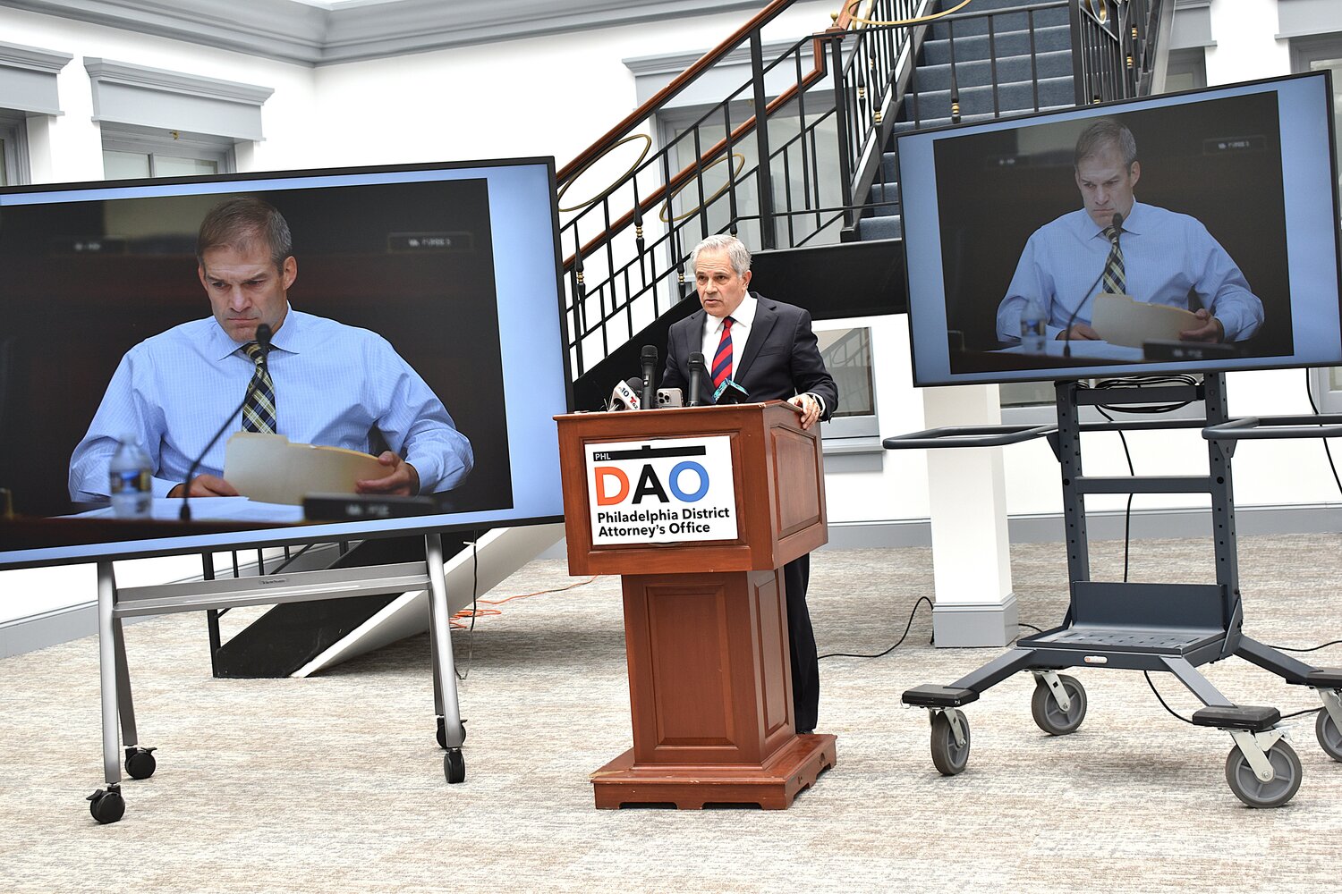 District Attorney Larry Krasner gives his response to a letter from Congressional Republicans as television monitors display a photograph of U.S. Rep. Jim Jordan during a news conference Wednesday, May 13, 2026.
