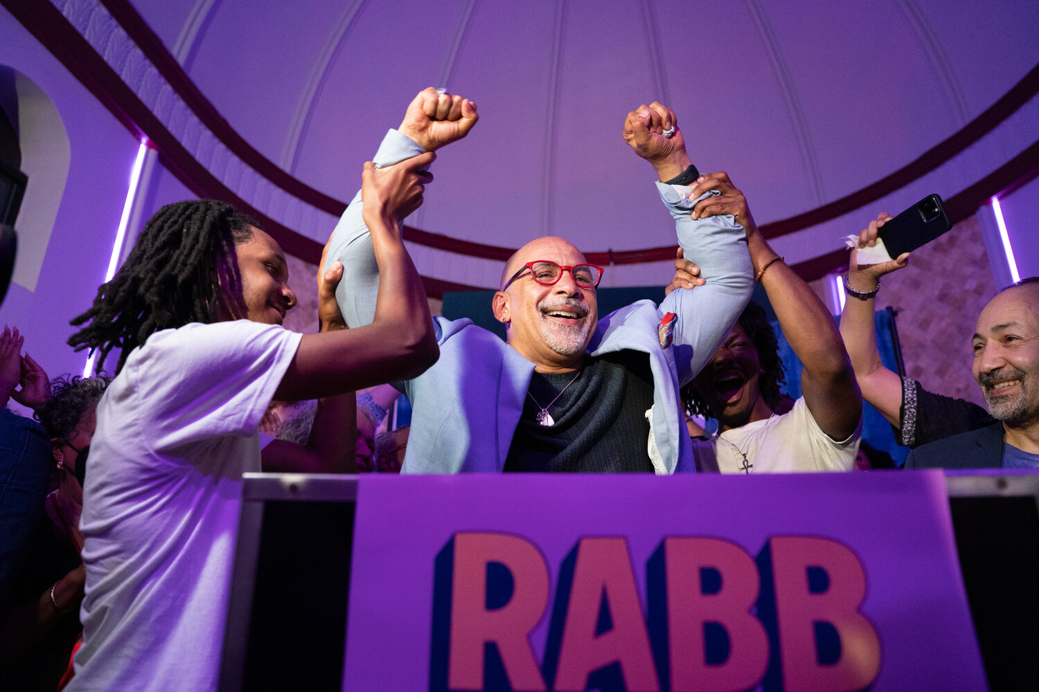 Pennsylvania State Rep. Chris Rabb smiles as his sons raise his arms after Rabb won the Democratic primary for Pennsylvania&rsquo;s 3rd Congressional District during an election night watch party at Victorian Banquet Hall in Philadelphia, on May 19, 2026. Rabb won the Democratic nomination to replace retiring U.S. Rep. Dwight Evans.