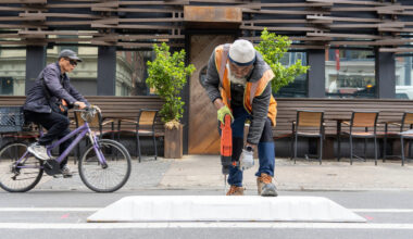 The Streets Department of Transportation install modular plastic curbs between Locust and Chestnut streets.