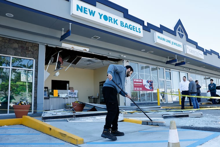 New York Bagels employee Tareq Kayyali sweeps glass from the parking lot after an explosion at the beloved Overbrook Park kosher bagel shop, along the 7500 block of Haverford Ave., on Sunday, May 10, 2026.
