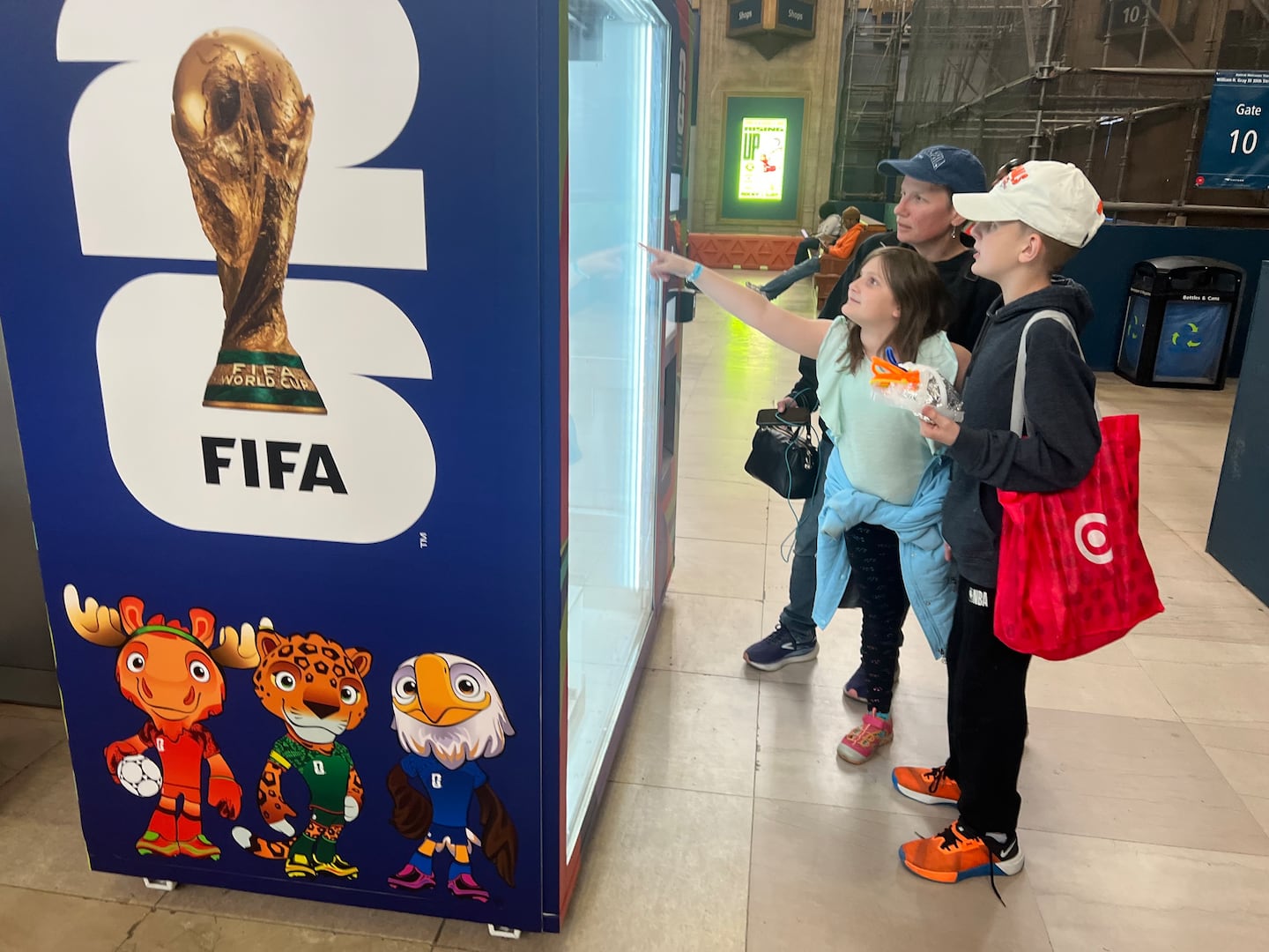 Michelle Riegert and her two children, Leah (9) and Zach (11), stopped at a kiosk selling FIFA World Cup merchandise at the 30th Street Station in Philadelphia.