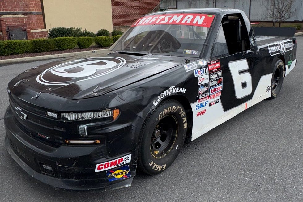 a racing truck parked outside a building a racing truck parked outside a building