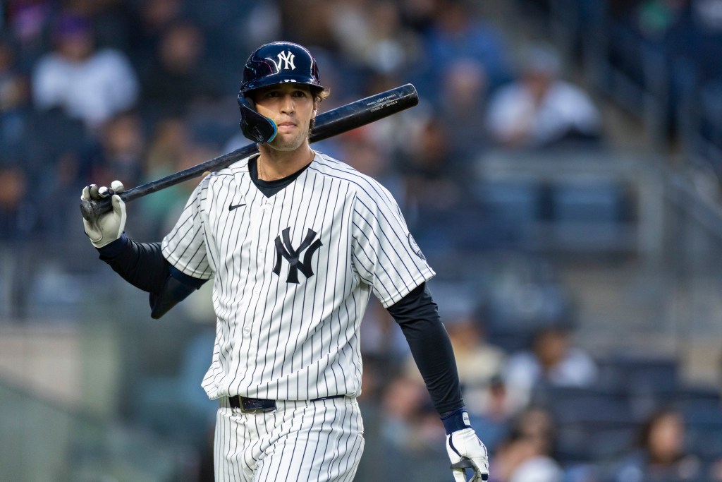 Spencer Jones of the New York Yankees on the field with a bat over his shoulder.