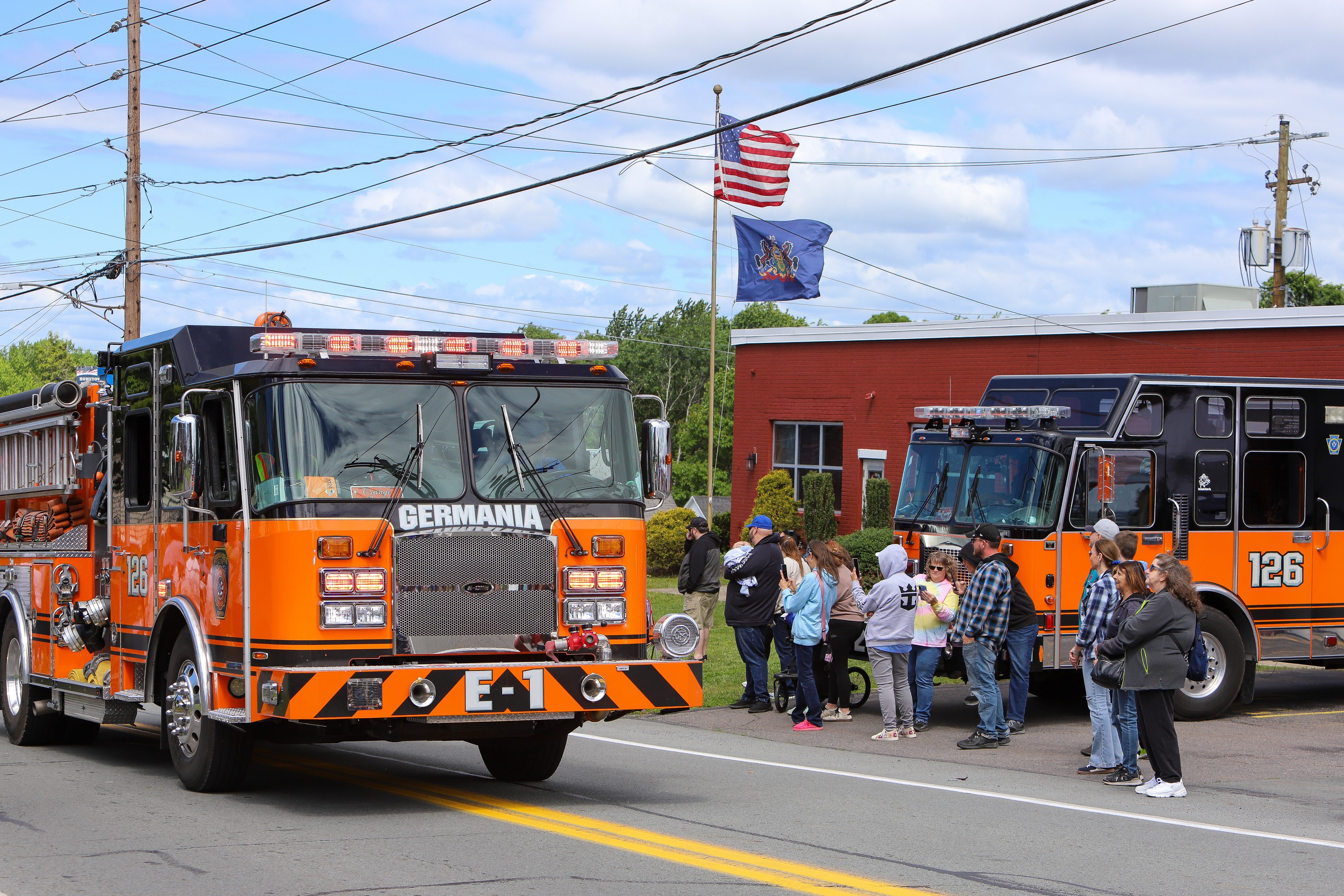 People watch the passing trucks during the Duryea Borough 125th...