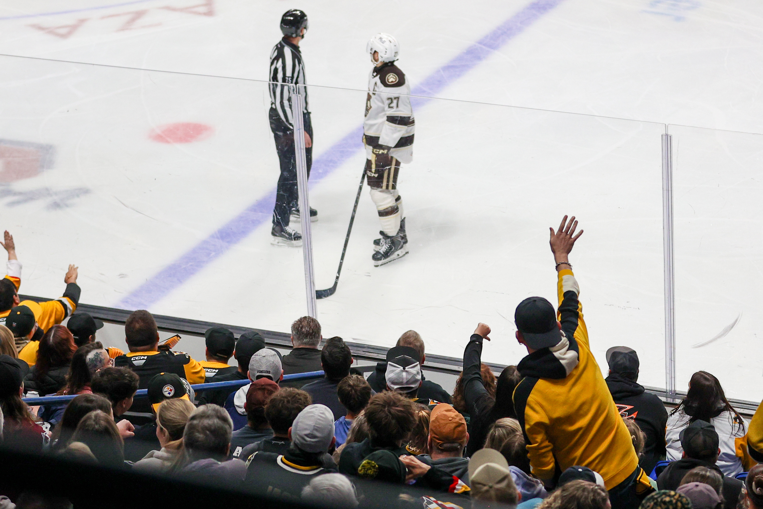 A fan waves as Hershey’s Aaron Ness is escorted to...