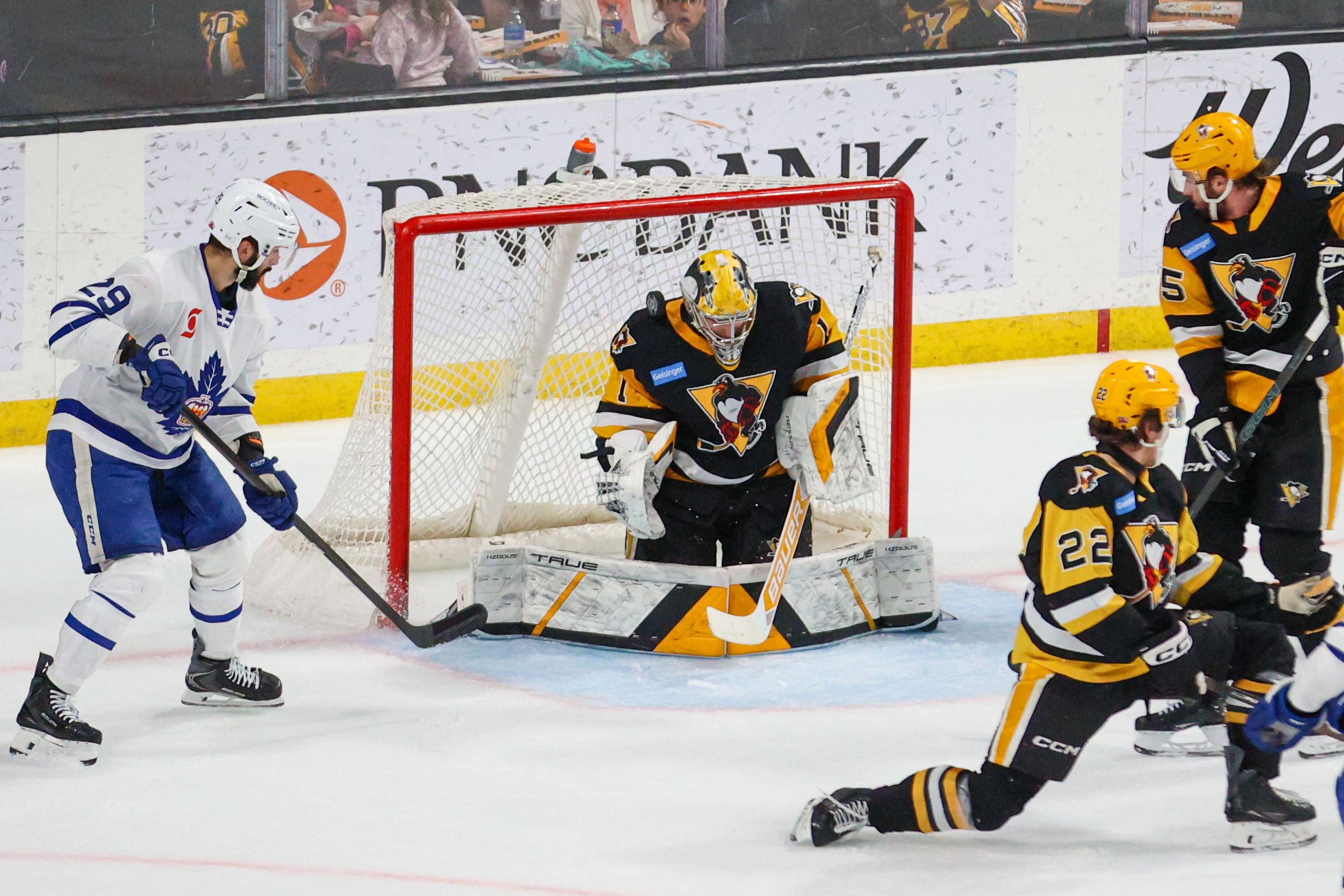 The puck deflects off of the shoulder of Penguins goalie...